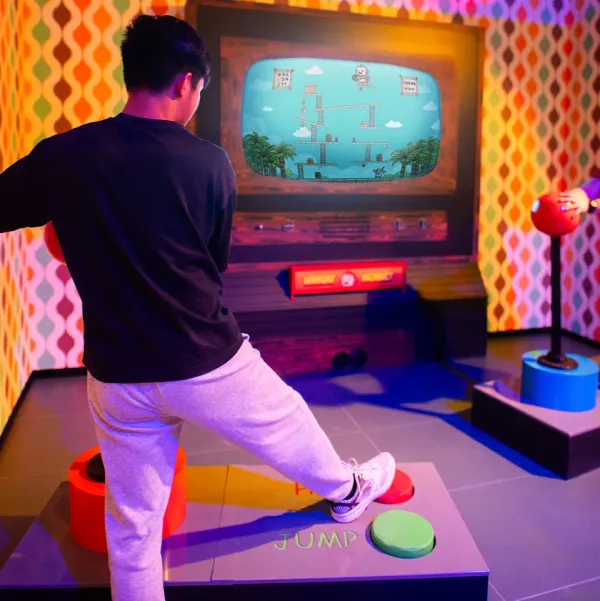 A player stamping the jump pad in front of the Hangry Monkey arcade screen